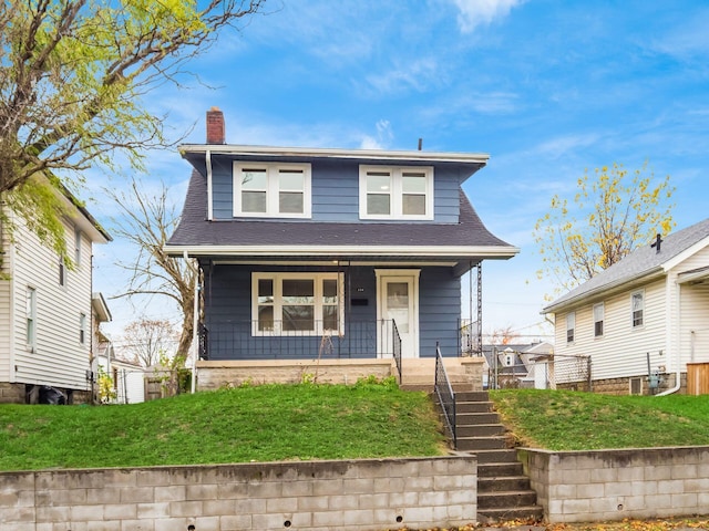 view of front of property featuring a front lawn and covered porch