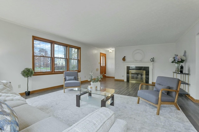 living room featuring crown molding, a high end fireplace, and dark wood-type flooring