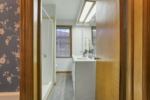 bathroom with toilet, vanity, and hardwood / wood-style flooring