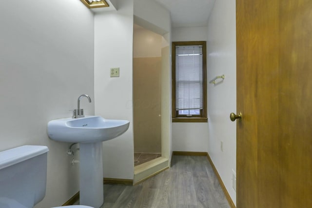 bathroom featuring hardwood / wood-style flooring, toilet, and walk in shower