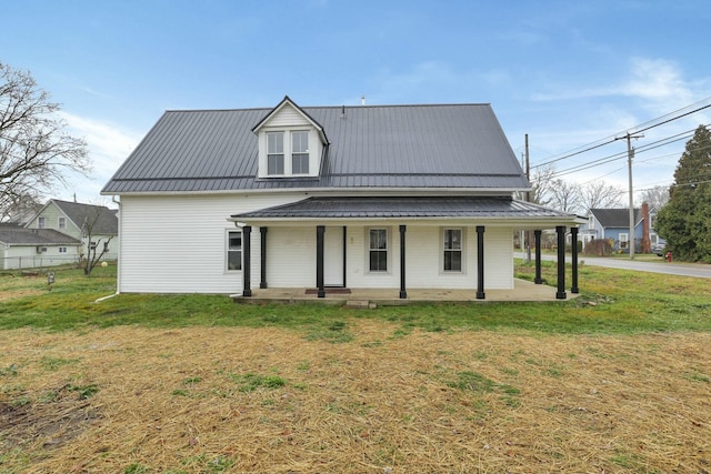 rear view of property with a yard and a porch