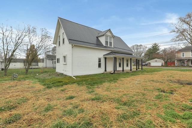 view of front facade with an outbuilding, a garage, a porch, and a front yard