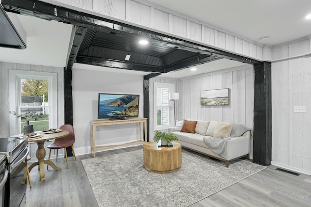 living room featuring light hardwood / wood-style floors and wooden walls