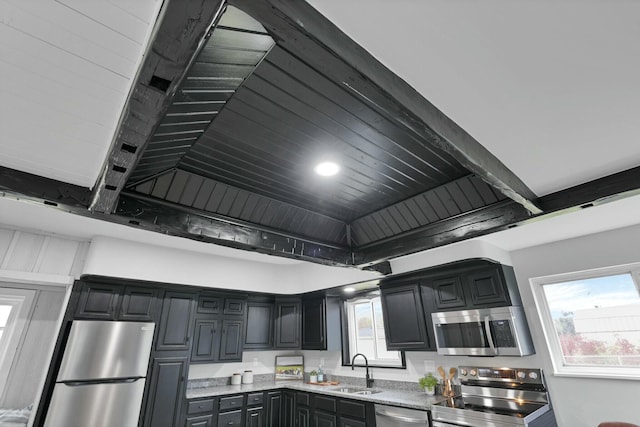 kitchen with light stone countertops, sink, and stainless steel appliances