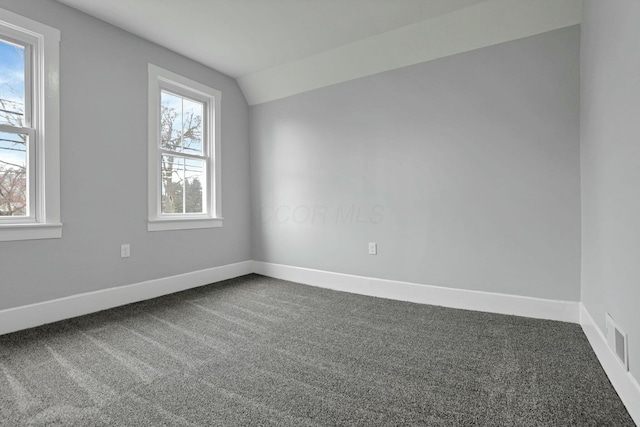 unfurnished room with carpet flooring and vaulted ceiling