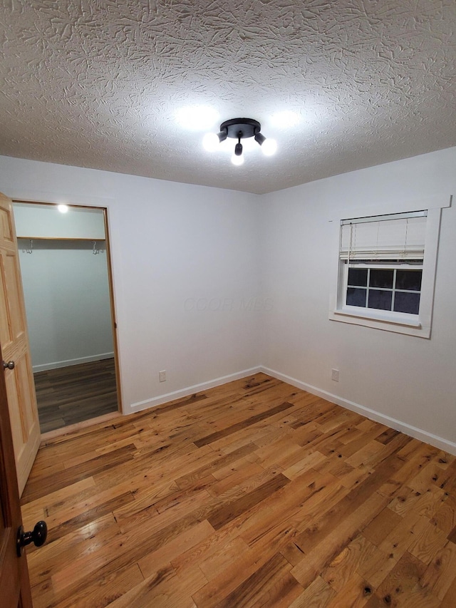 spare room with wood-type flooring and a textured ceiling