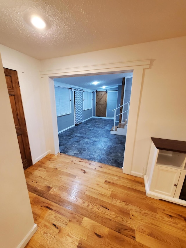 corridor featuring wood-type flooring and a textured ceiling