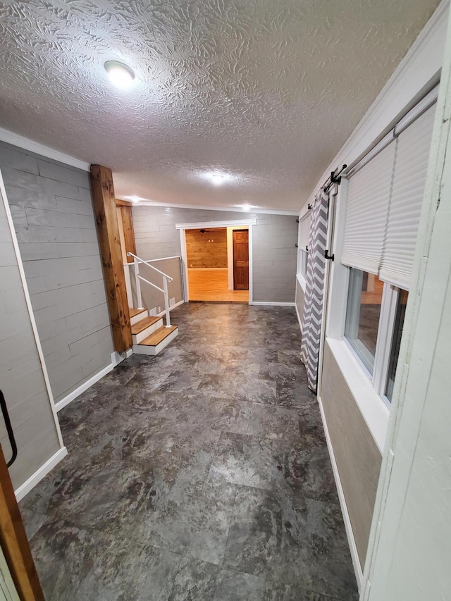 interior space with a barn door and a textured ceiling