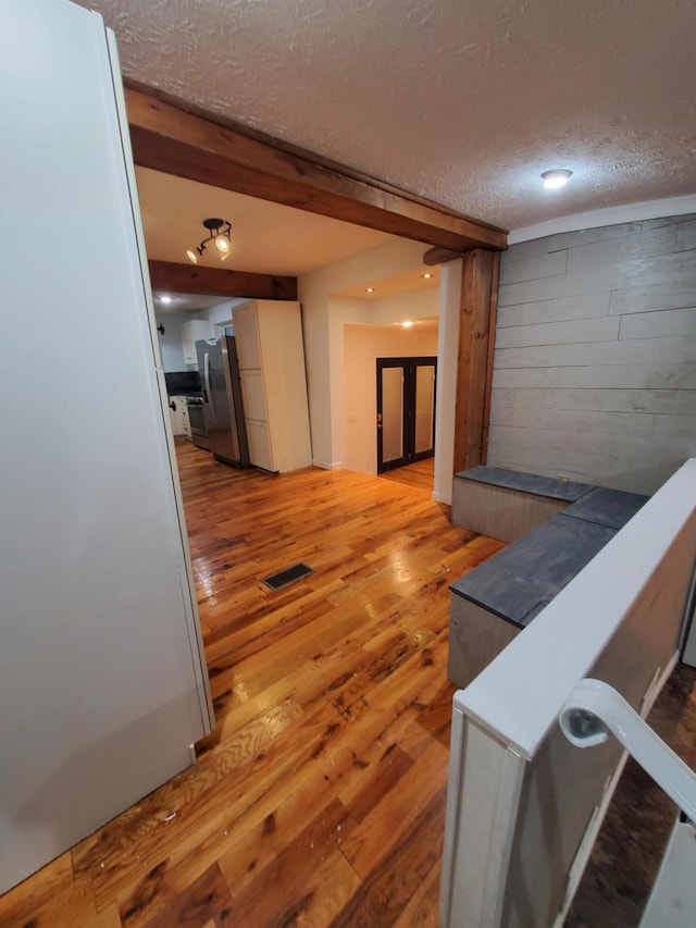 corridor featuring a textured ceiling and light hardwood / wood-style flooring