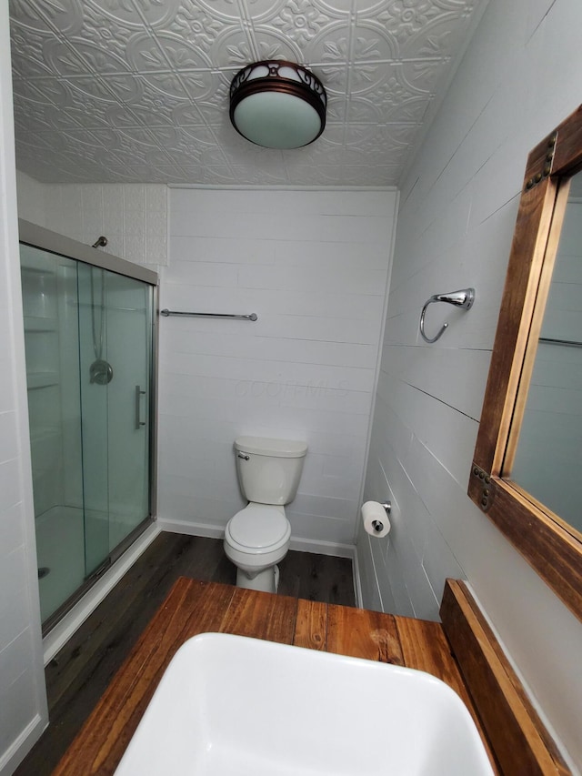 bathroom with hardwood / wood-style floors, toilet, and walk in shower