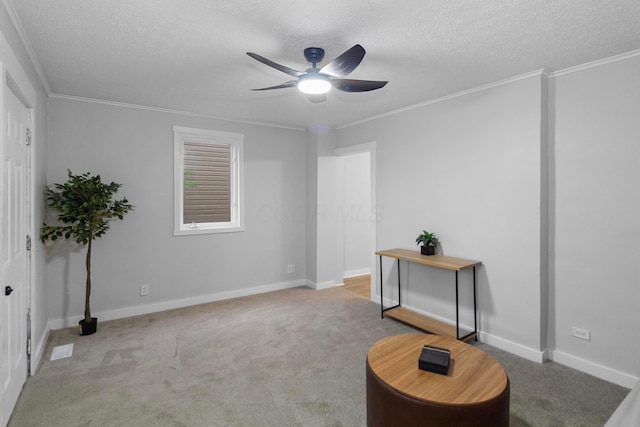 living area with a textured ceiling, light colored carpet, and ornamental molding