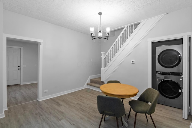 dining room featuring hardwood / wood-style floors, a textured ceiling, and stacked washer and dryer