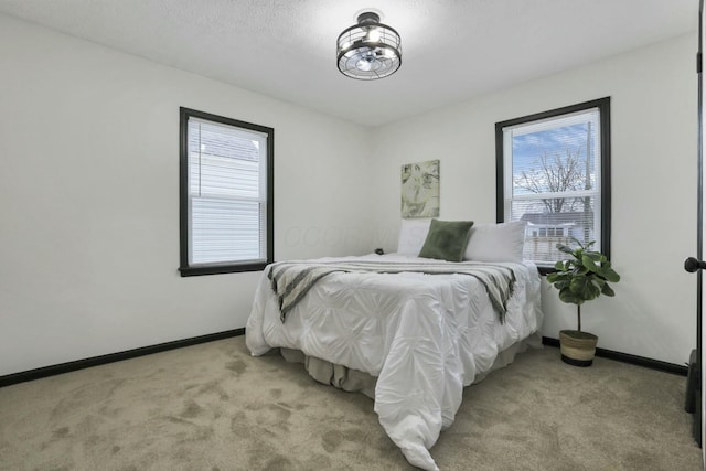 carpeted bedroom featuring multiple windows and a textured ceiling