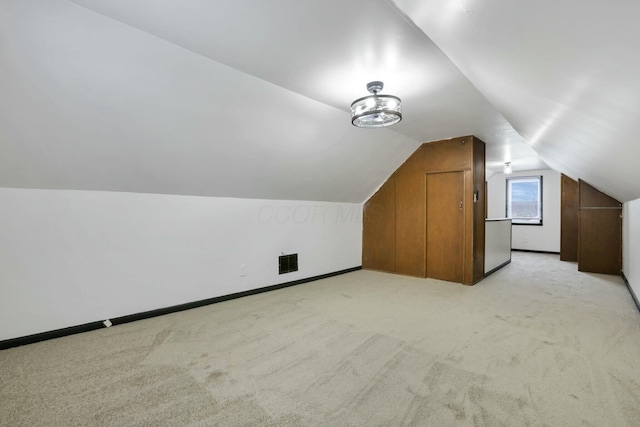 bonus room with vaulted ceiling and light carpet