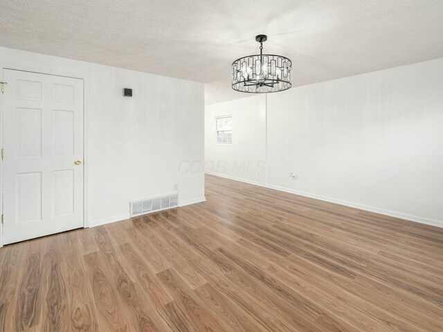5006 Old Tree Ave, Columbus, OH 43228 - unfurnished dining area with a chandelier, light wood-type flooring, and a textured ceiling
