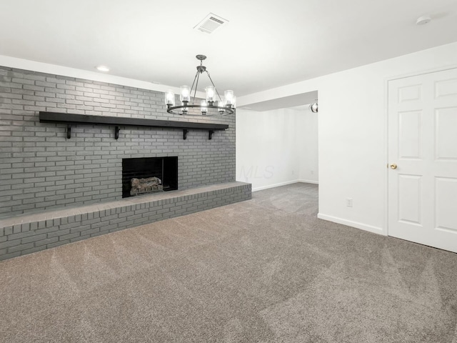 unfurnished living room featuring a fireplace, carpet floors, brick wall, and a notable chandelier