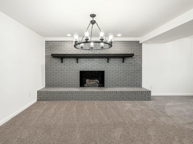 unfurnished living room featuring carpet flooring, a fireplace, brick wall, and an inviting chandelier