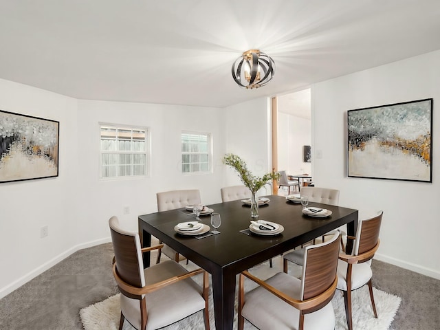 carpeted dining area with a chandelier