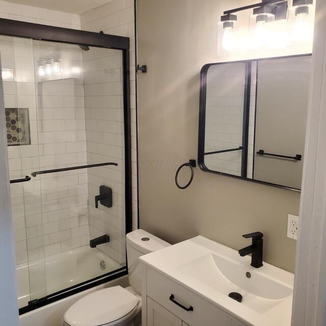 full bathroom with shower / bath combination with glass door, vanity, and toilet