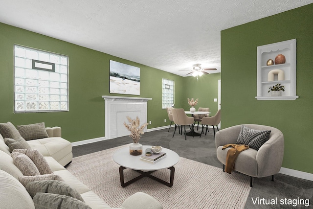 living room featuring ceiling fan, carpet, a healthy amount of sunlight, and a textured ceiling