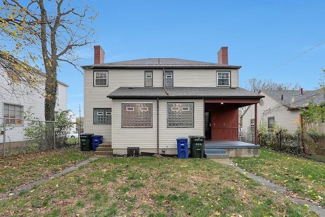 rear view of house featuring a yard