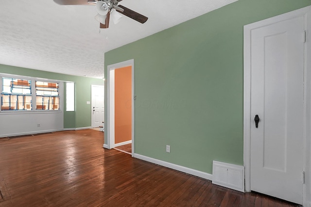 unfurnished room with ceiling fan, dark hardwood / wood-style flooring, and a textured ceiling