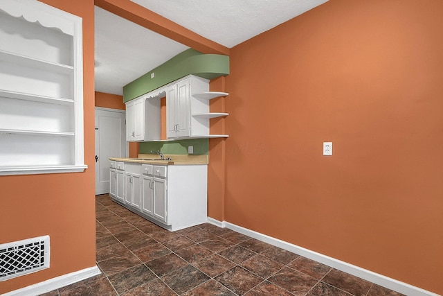 kitchen with white cabinetry and sink