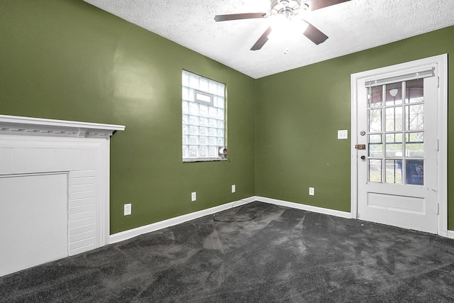 carpeted spare room featuring a textured ceiling and ceiling fan