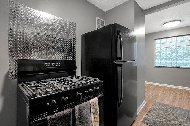 kitchen featuring light wood-type flooring and black appliances