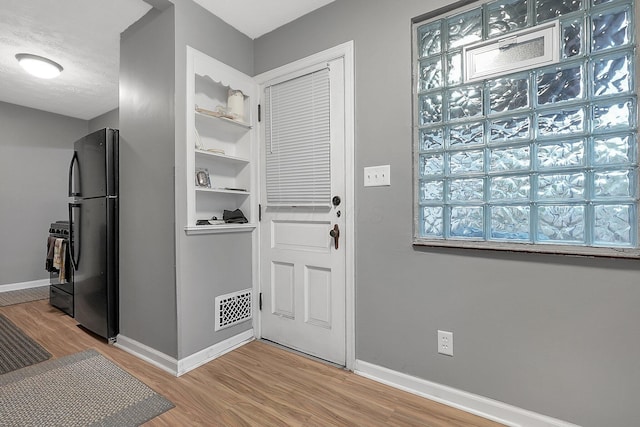 doorway to outside featuring a textured ceiling and hardwood / wood-style flooring