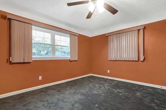 empty room with dark colored carpet and ceiling fan