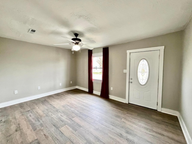 foyer featuring hardwood / wood-style flooring, ceiling fan, and a textured ceiling