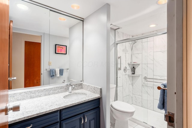 bathroom with vanity, toilet, and a shower with door