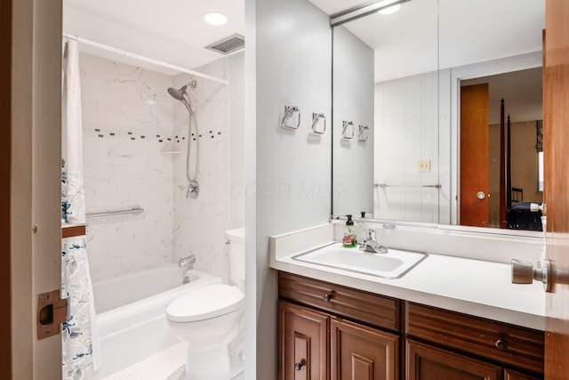 full bathroom with vanity, shower / bath combo, and toilet