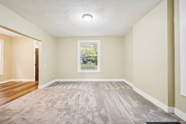 unfurnished room with carpet floors and a textured ceiling