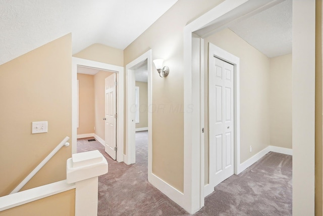 hall featuring carpet and a textured ceiling