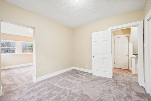 carpeted empty room with a textured ceiling