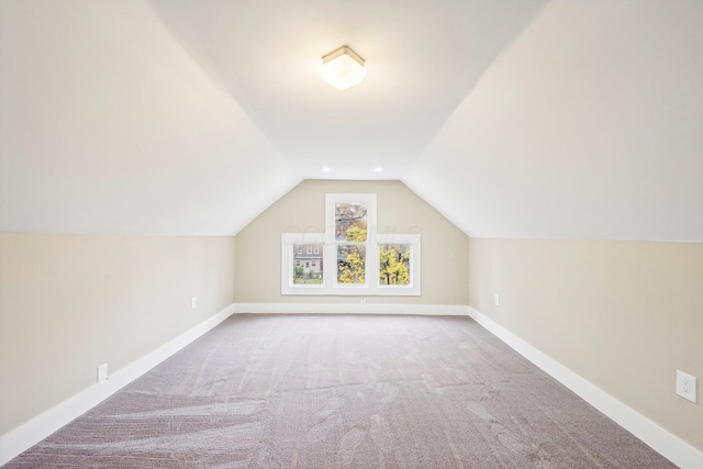 additional living space featuring carpet flooring and lofted ceiling