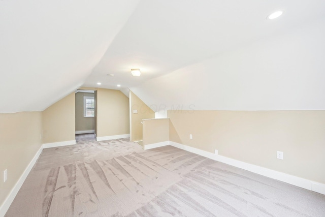 bonus room with light carpet and vaulted ceiling