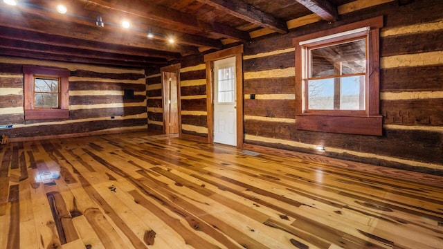 unfurnished living room with beam ceiling, hardwood / wood-style floors, and wood ceiling