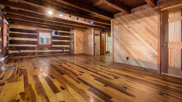 unfurnished living room featuring beamed ceiling, hardwood / wood-style floors, wooden walls, and wood ceiling