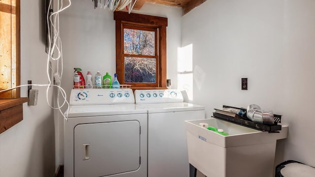 clothes washing area featuring washer and clothes dryer and sink