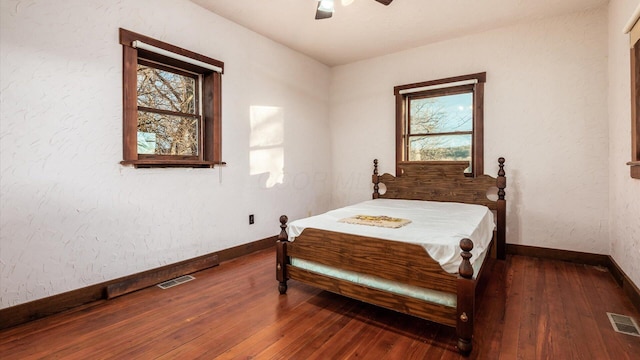 bedroom with hardwood / wood-style floors, multiple windows, and ceiling fan