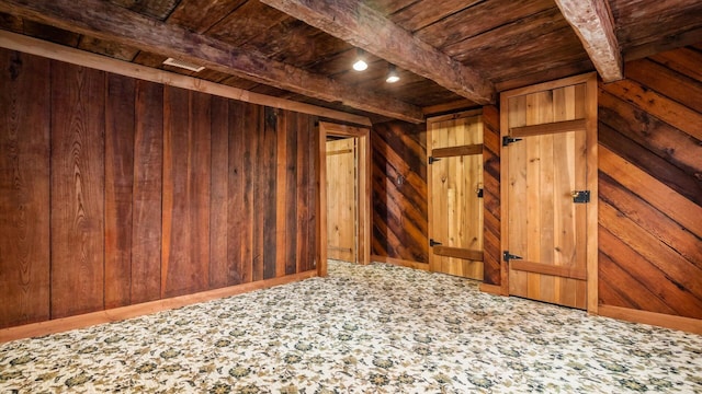 interior space featuring wood walls, beam ceiling, and wooden ceiling