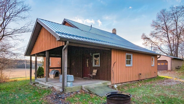 back of property with a garage and an outbuilding