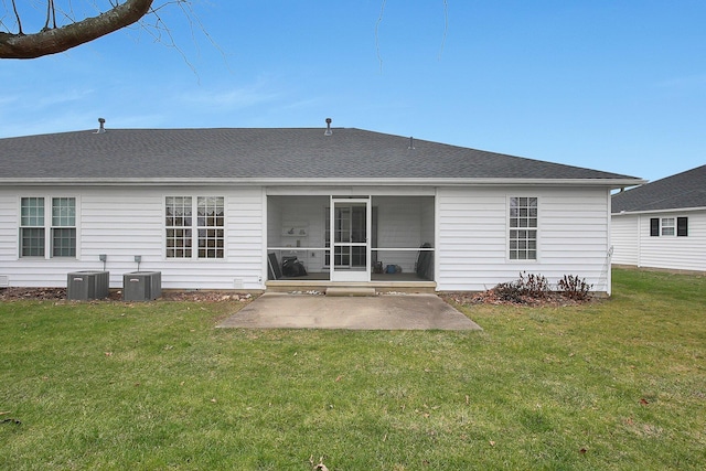 rear view of property with central AC unit, a sunroom, a patio area, and a lawn