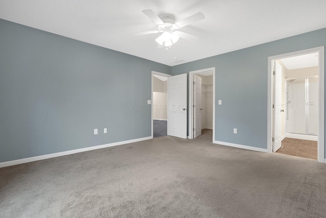 unfurnished bedroom with a walk in closet, ceiling fan, connected bathroom, carpet floors, and a closet