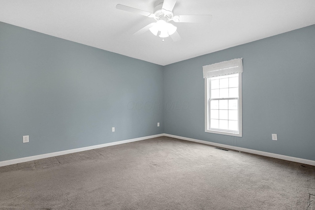 carpeted spare room featuring ceiling fan