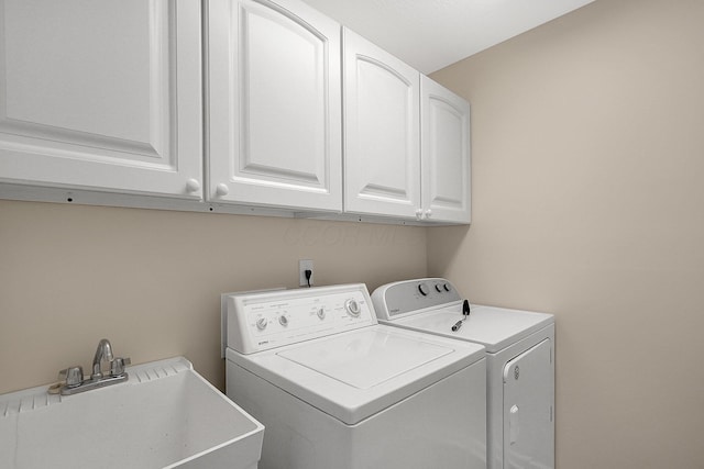 washroom featuring cabinets, sink, and washing machine and dryer