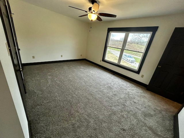 carpeted spare room featuring ceiling fan